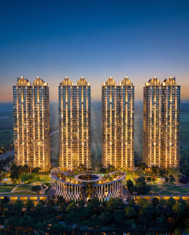 Gaur Alaris — art-deco tower crowns lit at blue hour (builder render, artistic visualization)